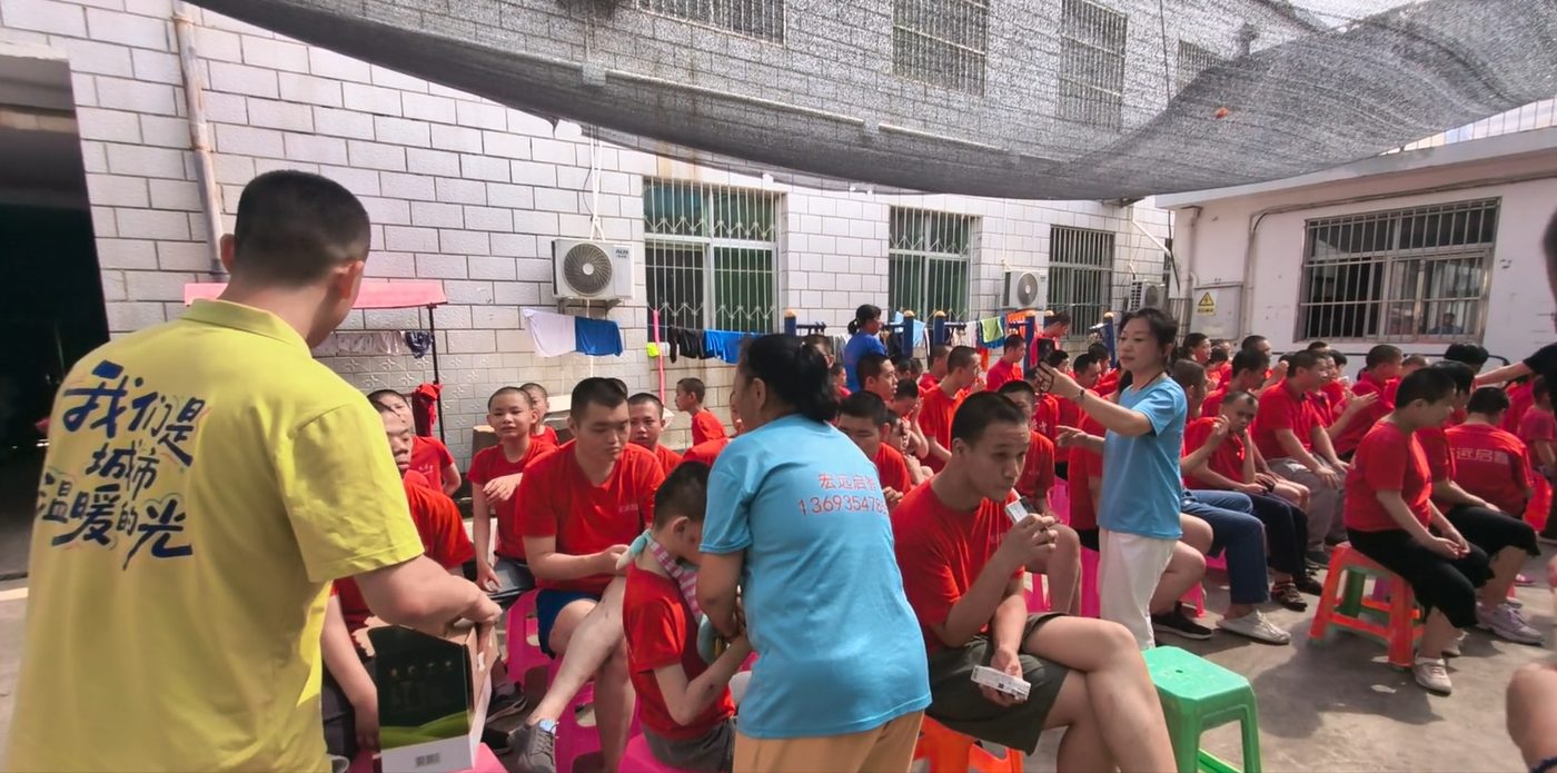 志愿者与托养中心的孩子们在院子里互动